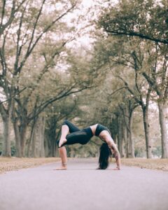 woman-does-bridge-pose-yoga-on-path